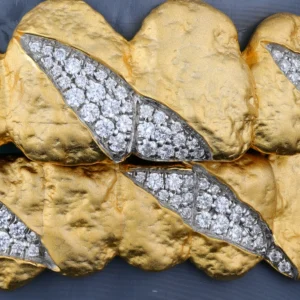 Textured gold-tone grillz with clear stone claw-mark details.