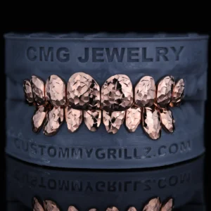 Rose gold-tone grillz with a faceted crushed ice texture.