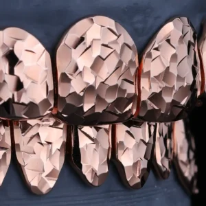 Rose gold-tone grillz with a faceted crushed ice texture.
