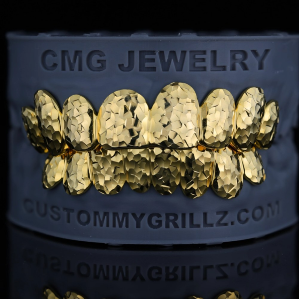 Gold-tone full-set grillz with a faceted crushed-ice surface pattern.