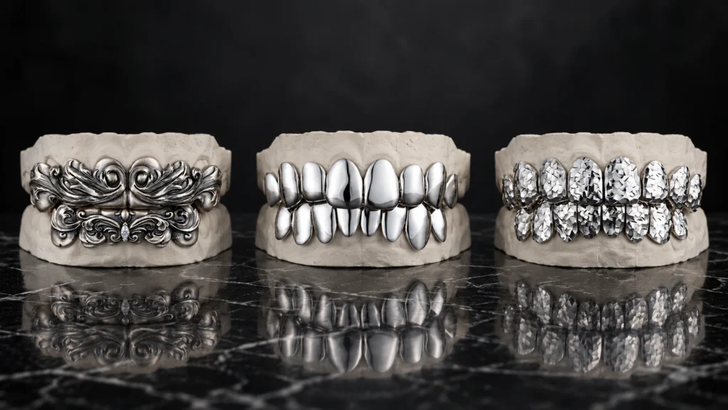 Three silver grillz designs in vintage engraved, high-polish, and crushed-ice finishes displayed on dental models