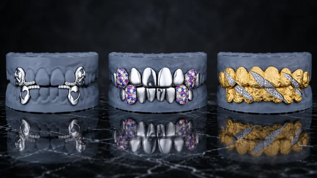 Three custom fang and canine grillz layouts displayed on dental models